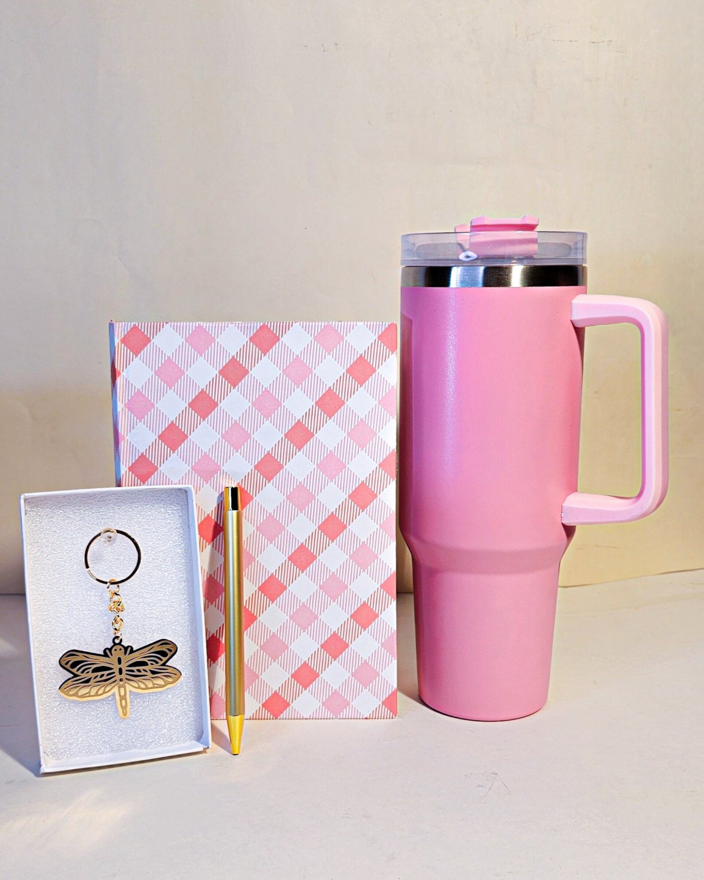 Pink tumbler, checkered notebook, and keychain gift hamper