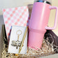 Pink tumbler, checkered notebook, and keychain in a gift box with straw filler.
