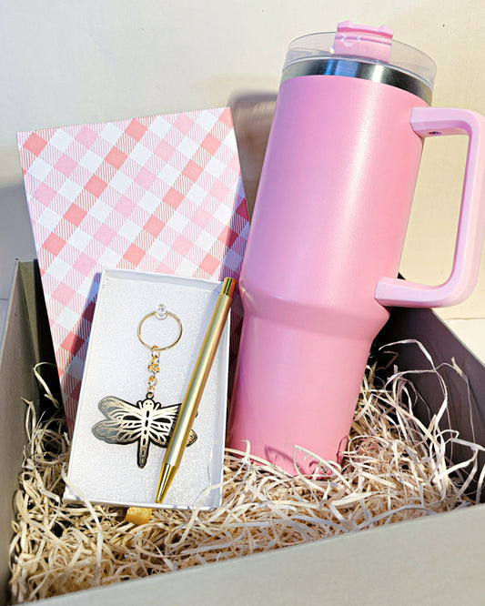 Pink tumbler, checkered notebook, and keychain in a gift box with straw filler.